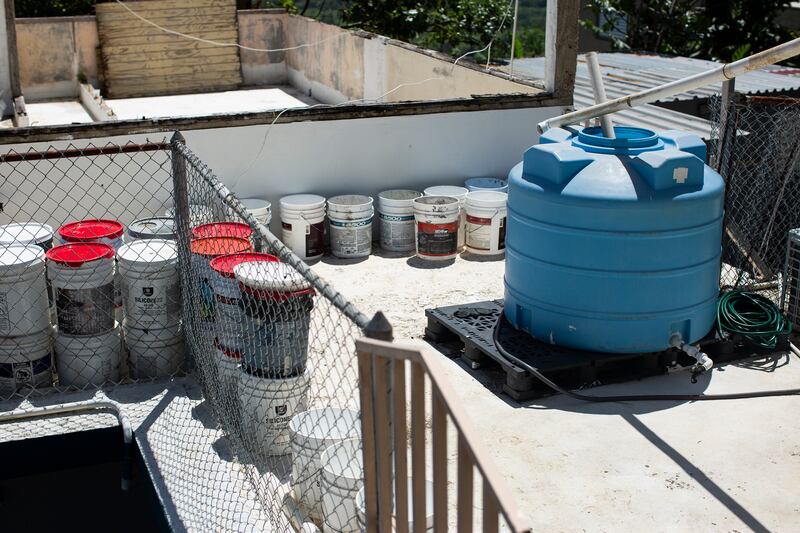 Más de una decena de cubos y una cisterna azul llenas de aguas en una residencia en Moca.