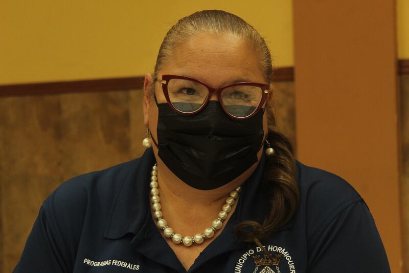 Sandra E. Rosas Vélez en una foto close-up, con mascarilla negra, espejuelos, el cabello en una cola y una camisa polo que la identifica como parte del Municipio de Hormigueros.