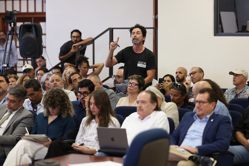 Esencia, según los proponentes, tendría cuatro accesos públicos vehiculares a la playa, los cuales están en controversia. Los ciudadanos denuncian que para acceder a la playa por esos caminos habría que atravesar accesos que privatizan el área debido a que la entrada con vehículos será controlada.

 

Fuera del ayuntamiento, ciudadanos se manifiestan en contra del proyecto financiado por la firma de inversión británica Reuben Brothers y la desarrolladora Three Rules Capital. Al ritmo de música y estribillos levantan pancartas dibujadas a mano en cartulina con consignas en contra de Esencia.

 

El salón no es lo suficientemente grande para acoger a todos los que se presentan para escuchar y expresarse a favor o en contra. Casi no hay sillas vacías. Así que los menos afortunados tienen que esperar afuera bajo una carpa blanca y ver la vista pública a través de un televisor que instaló alguna de las organizaciones que se han movilizado en contra del proyecto. Para entrar a la alcaldía, unos cuatro policías municipales solicitan a los asistentes que firmen una hoja de registro, les inspeccionan con un detector de metales y revisan sus bultos.