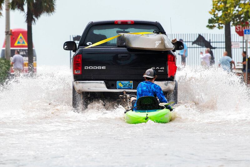 Un camión arrastra a un hombre en un kayak en un camino bajo después de una inundación tras el paso del huracán Ian, en Key West, Florida, el miércoles 28 de septiembre de 2022 por la tarde. (Foto AP/Mary Martin)