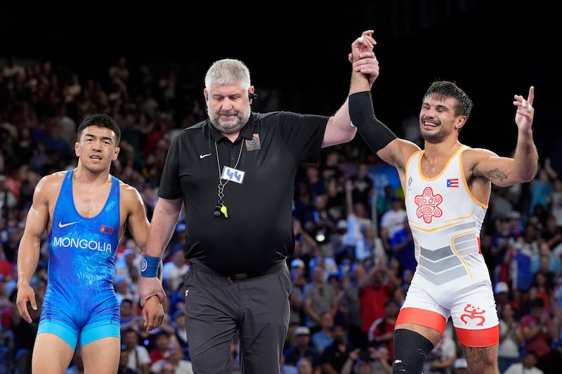 El puertorriqueño Sebastián Rivera celebra después de derrotar a Tumur Ochir Tulga de Mongolia en su combate por la medalla de bronce en la categoría libre masculina de 65 kg en la Arena Champ-de-Mars, durante los Juegos Olímpicos de Verano de 2024, el domingo 11 de agosto de 2024, en París, Francia. (Foto AP/Eugene Hoshiko)