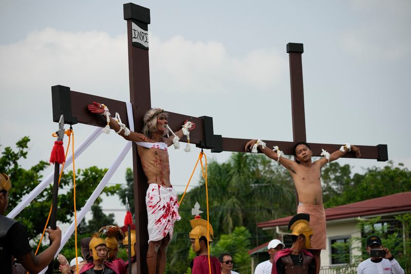 Wilfredo Salvador, a la izquierda, permanece en una cruz durante una recreación de los sufrimientos de Jesucristo como parte de los rituales del Viernes Santo el 7 de abril de 2023 en el pueblo de San Pedro, Cutud, provincia de Pampanga, al norte de Filipinas. Las crucifixiones de la vida real, una sangrienta tradición del Viernes Santo que es rechazada por la iglesia católica, se reanudan en este pueblo agrícola después de una pausa de tres años debido a la pandemia de coronavirus. (AP Photo/Aaron Favila)